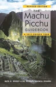 Portada de The Machu Picchu Guidebook edición revisada por Ruth M. Wright y Dr. Alfredo Valencia Zegarra, guía de tour autoguiado con vista aérea de ruinas incas y montañas